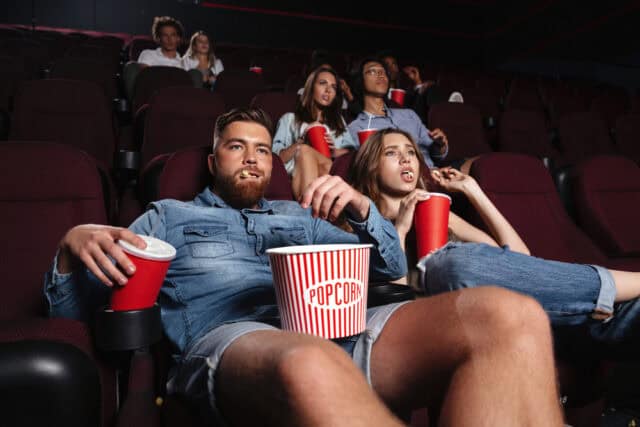 Man eating popcorn in the theater.