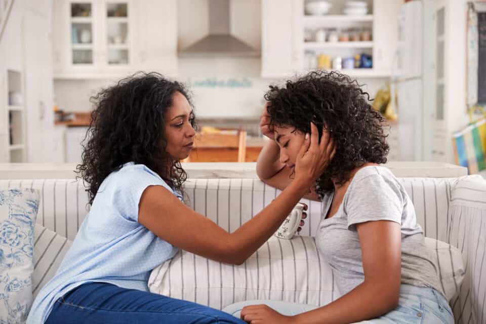 Mother and daughter talking on the couch.