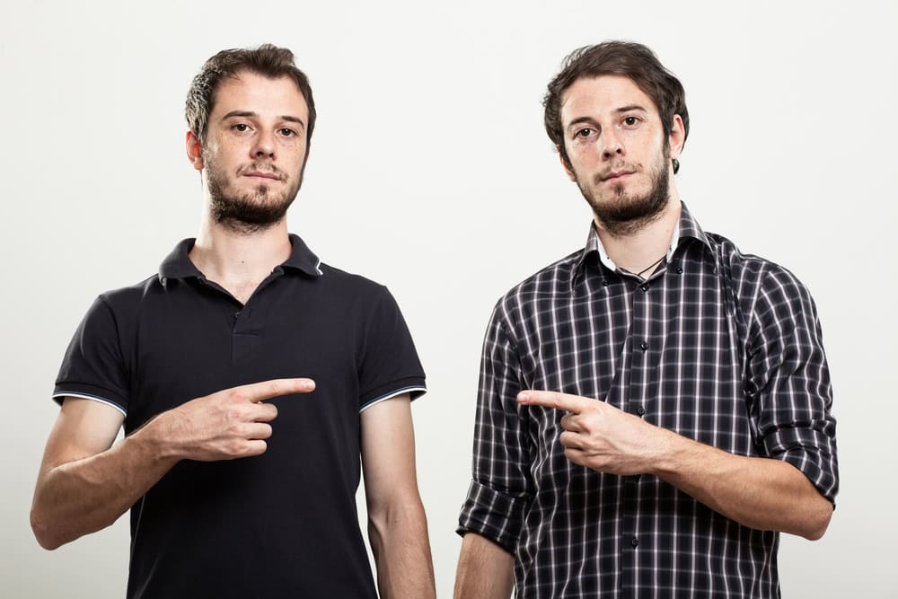 Twins pointing to one another.