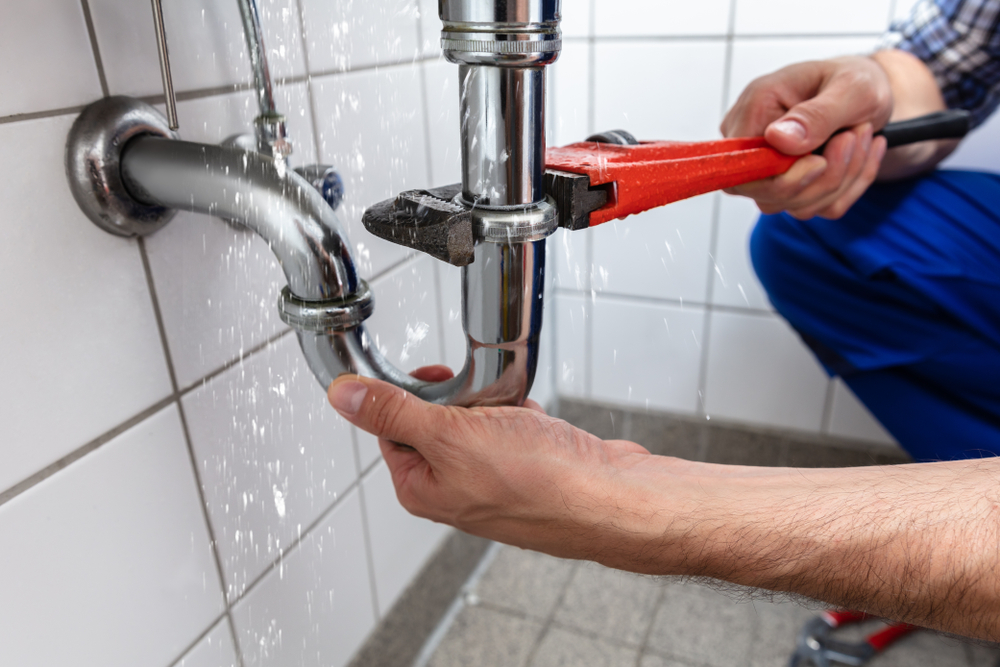 A man fixing his leaky sink.
