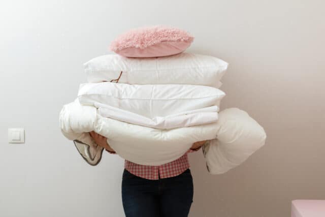 Woman holding a pile of laundry.