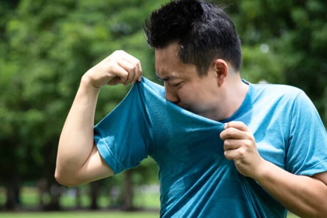Young man smelling his underarms.