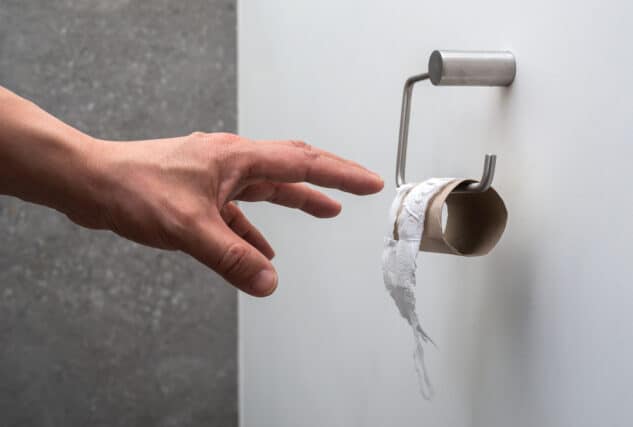 Hand reaching for toilet paper.