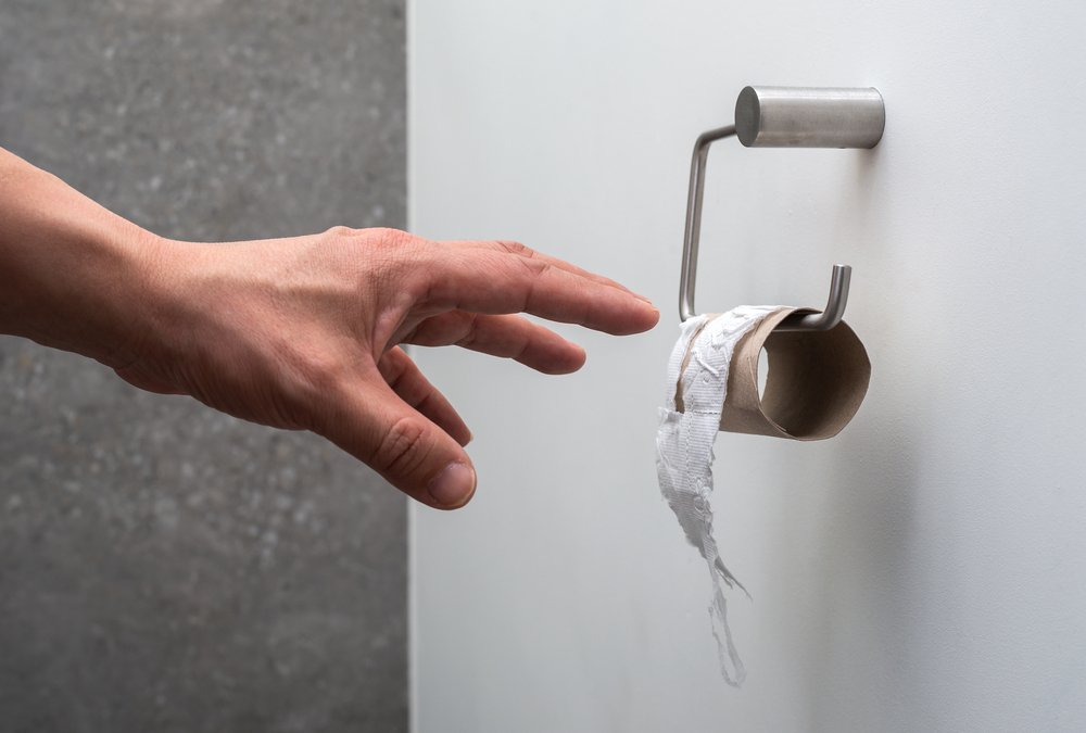 Hand reaching for toilet paper.