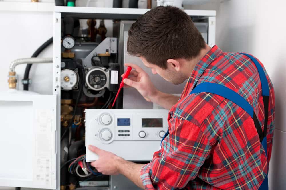 Technician servicing the gas tank in a home.