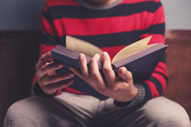Man reading a book alone.