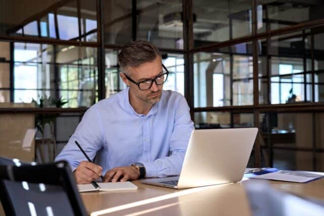 Man watching his computer in his office.