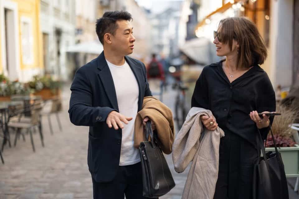 Two colleagues walking on the street talking.
