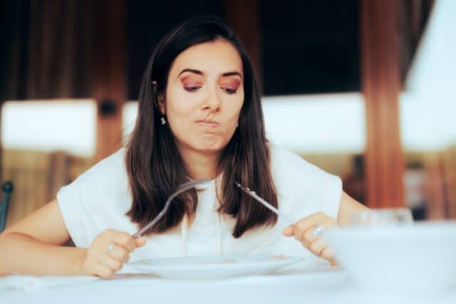 Woman at a restaurant with no food on her plate.
