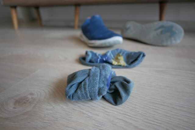 Dirty socks and shoes on the ground.