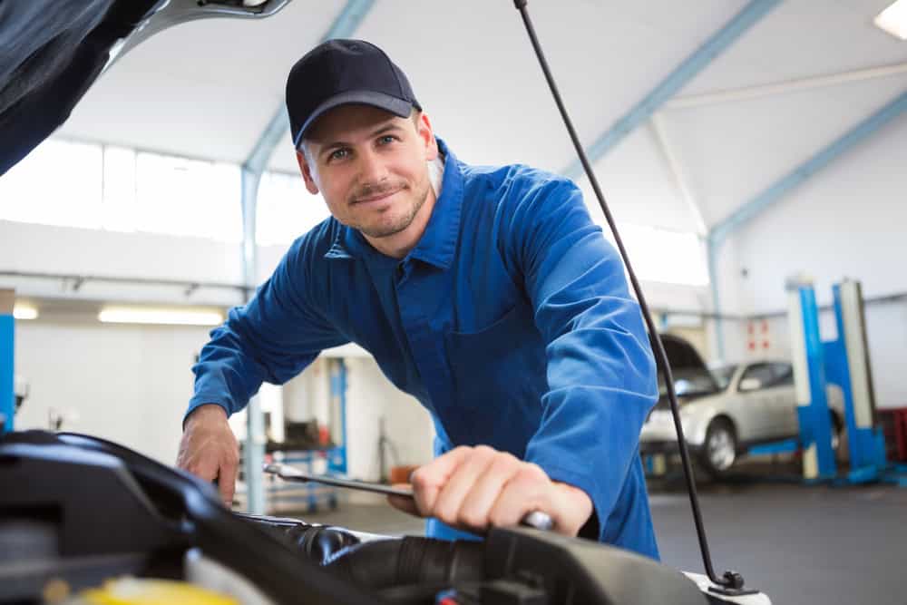 Mechanic under hood of car.