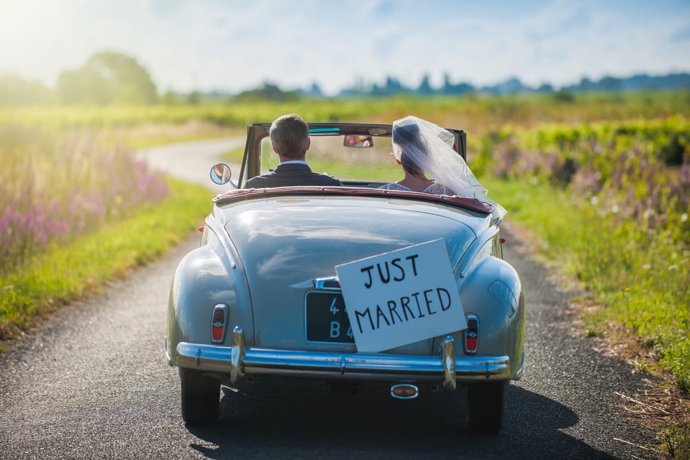 An old car with a Just Married sign on the back.