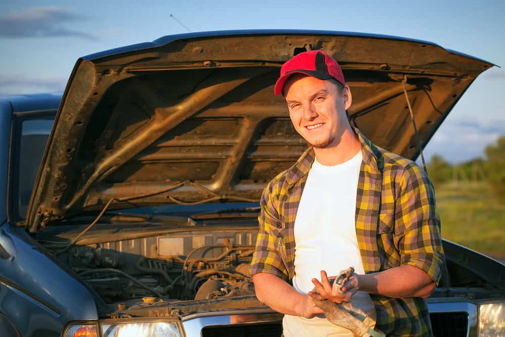 Man fixing car outside.