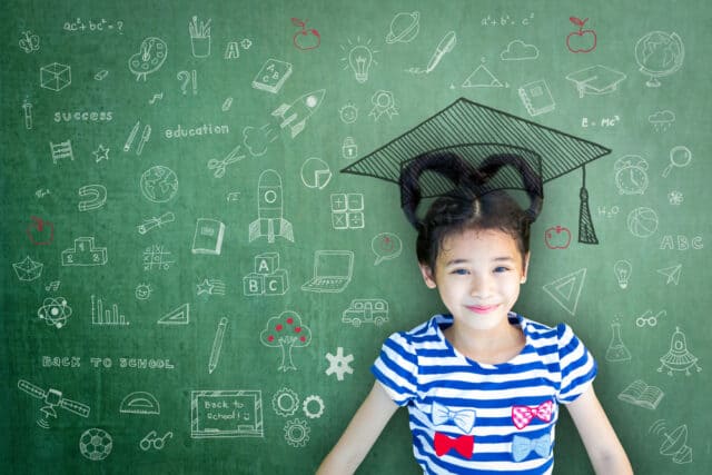 Schoolgirl in front of a blackboard full of numbers.