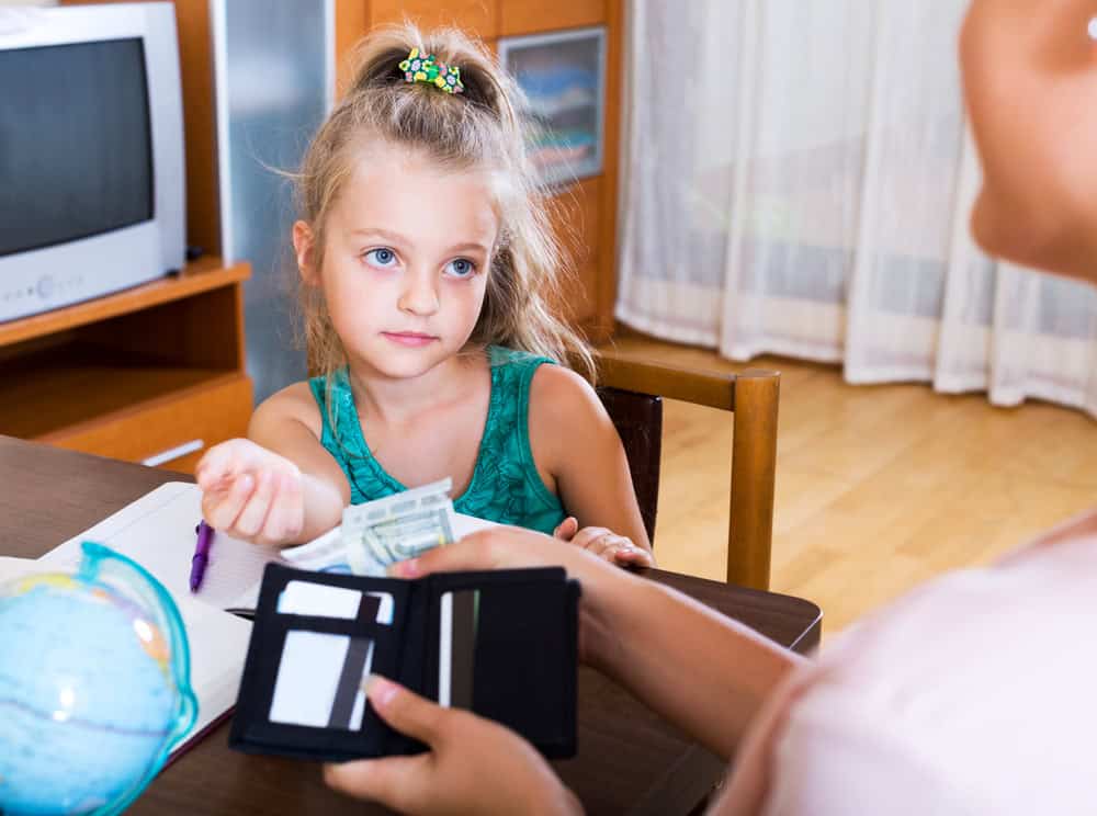 Little girl with her mother's wallet.