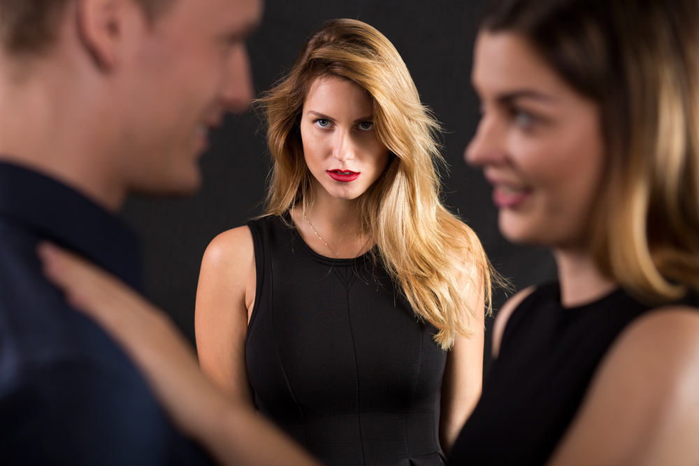 A woman looks at a couple with jealousy