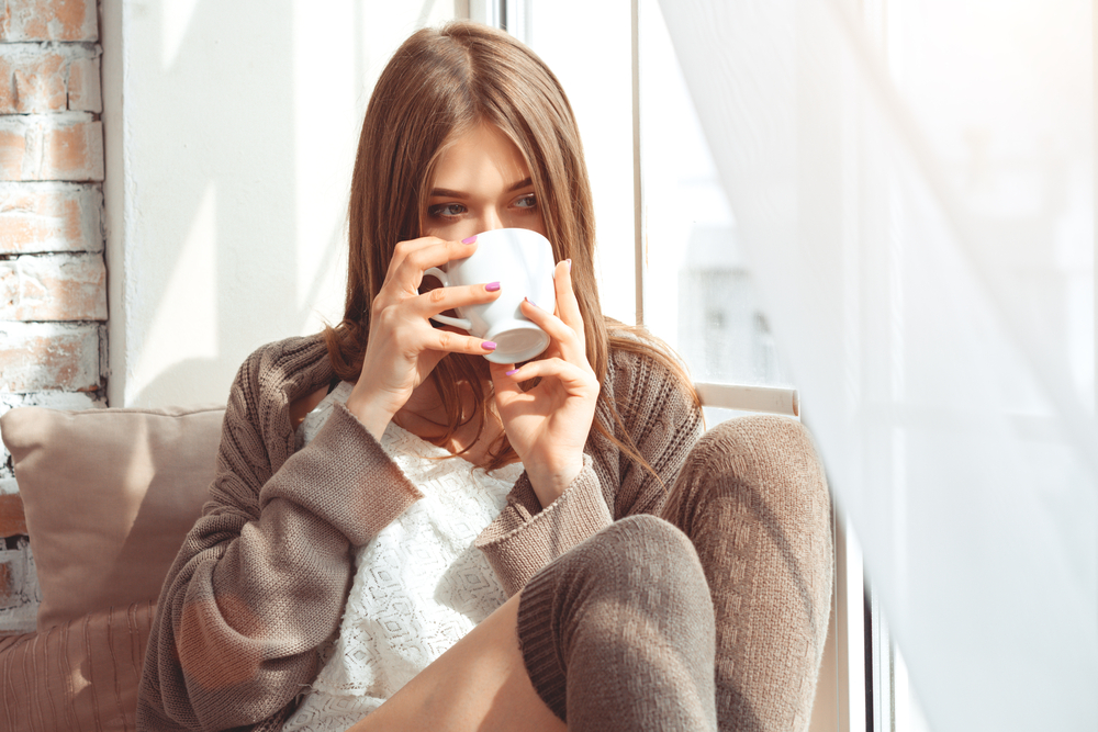 Woman having coffee at her window.