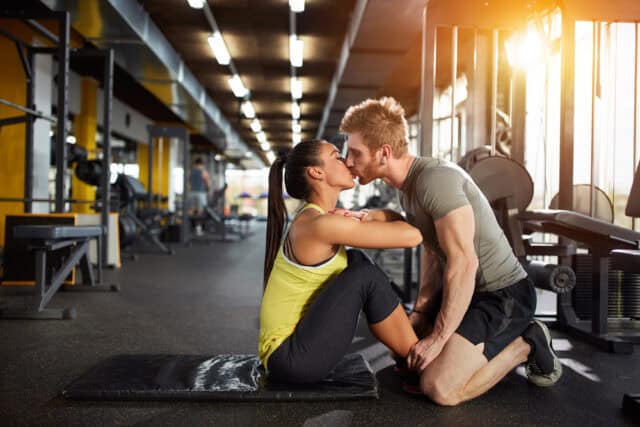 Couple kissing at the gym.