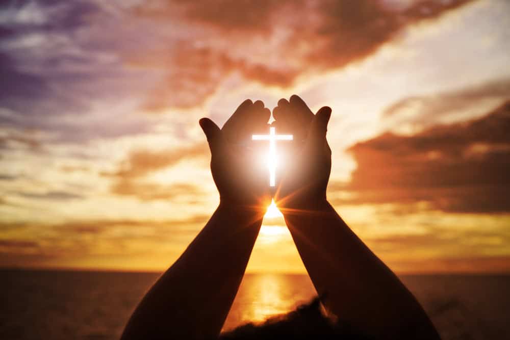 Hands with a cross symbol.