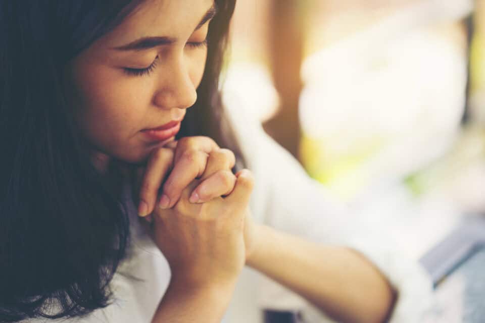 Woman praying outside.