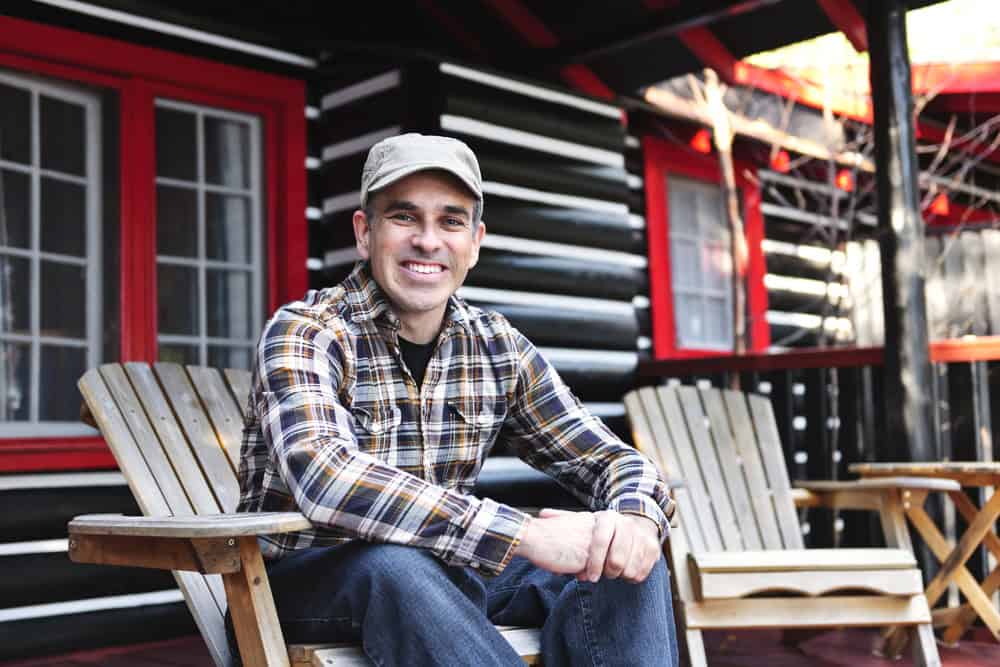 Man smiling sitting outside.