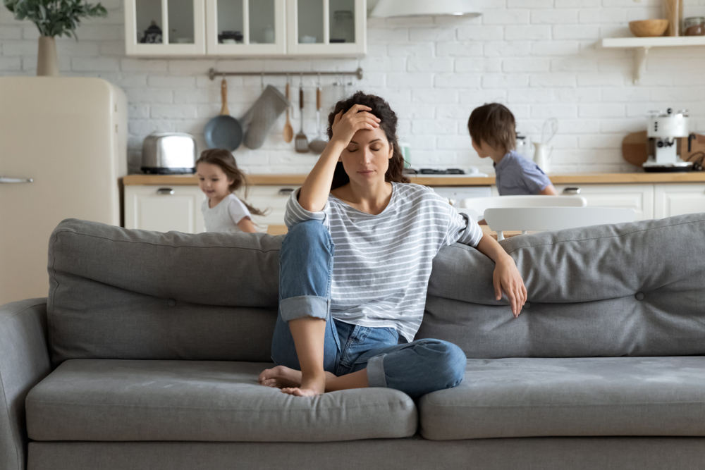 A tired mother with her children running around