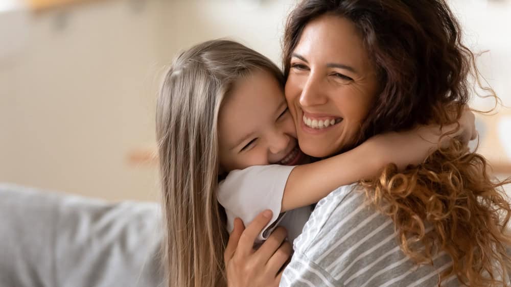 Little girl cuddling with her mother. 