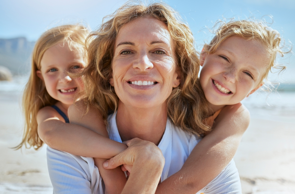 A mature woman with her children playing outside.