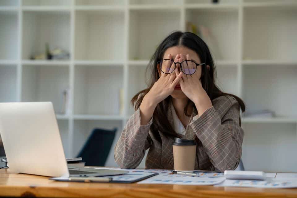 Tired woman rubbing her eyes.