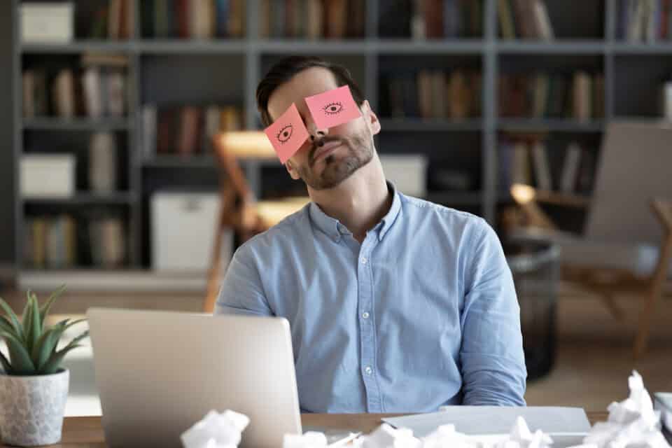 Exhausted man trying to work.