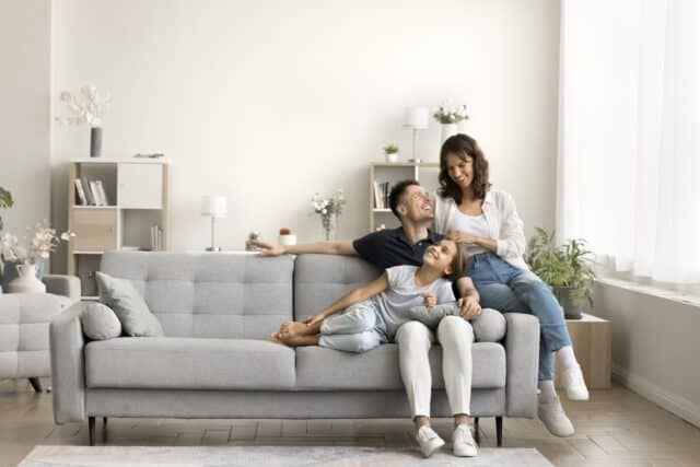 Young family sitting together on the couch.