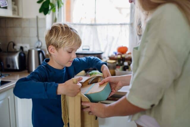 Mom packing snacks for her son.