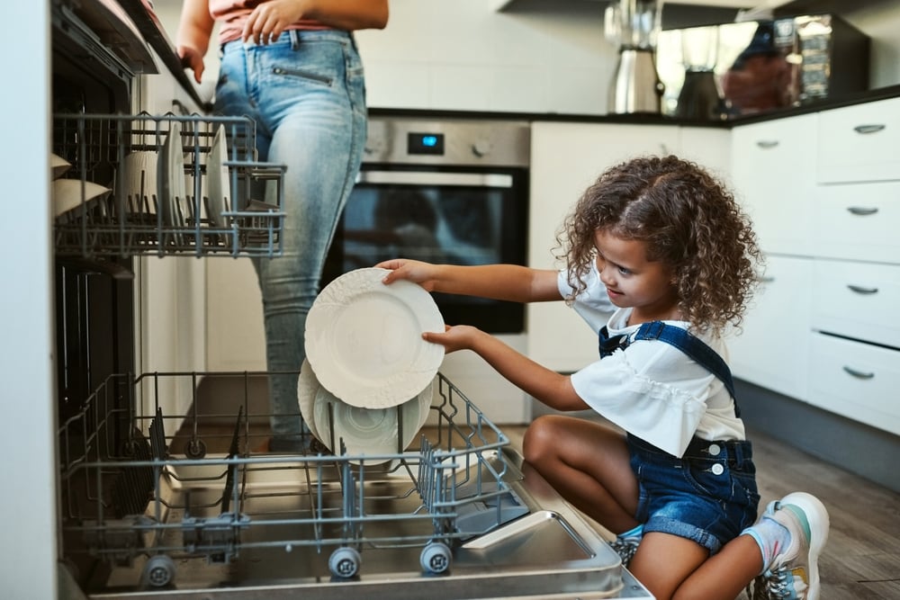 Parent and child loading the dishwasher.
