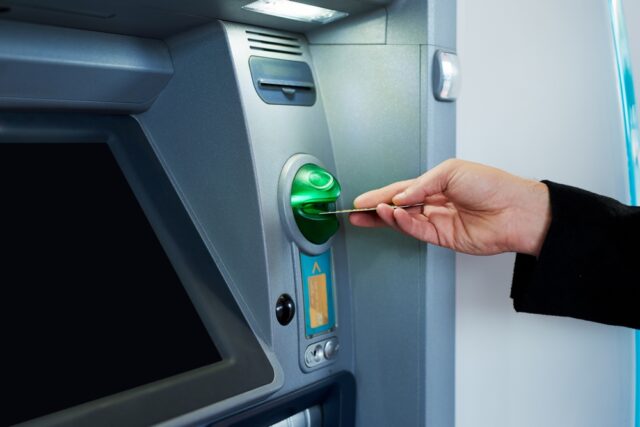 Hand getting money from the ATM.