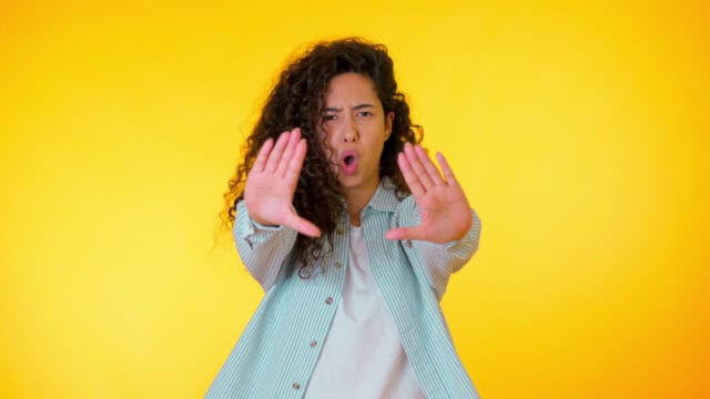 Annoyed woman saying no with her hands.