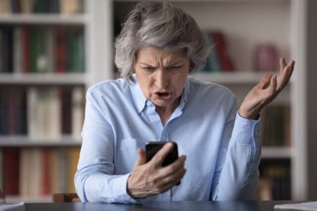 Older woman frustrated with her phone.