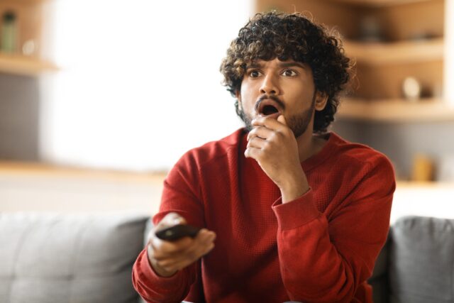 Man holding the TV remote.