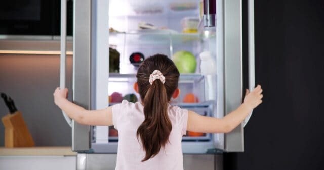 Girl checking the fridge.