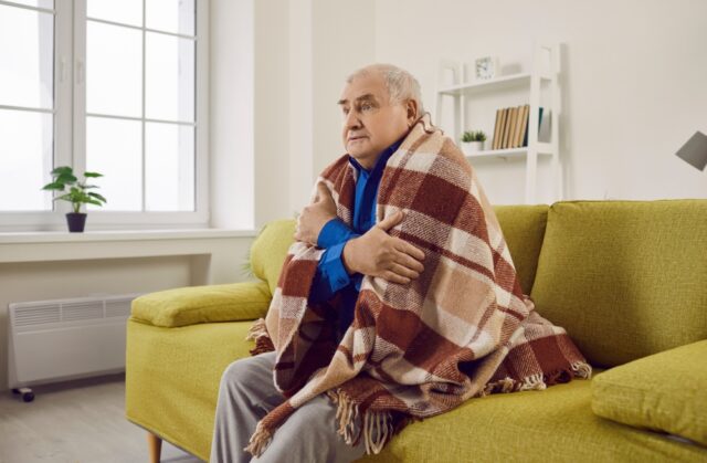 Man sitting with a blanket.