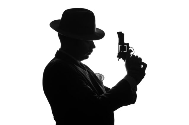 Silhouette of a man holding a gun.