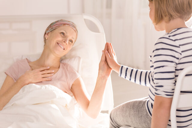 Cancer patient lying in hospital bed.