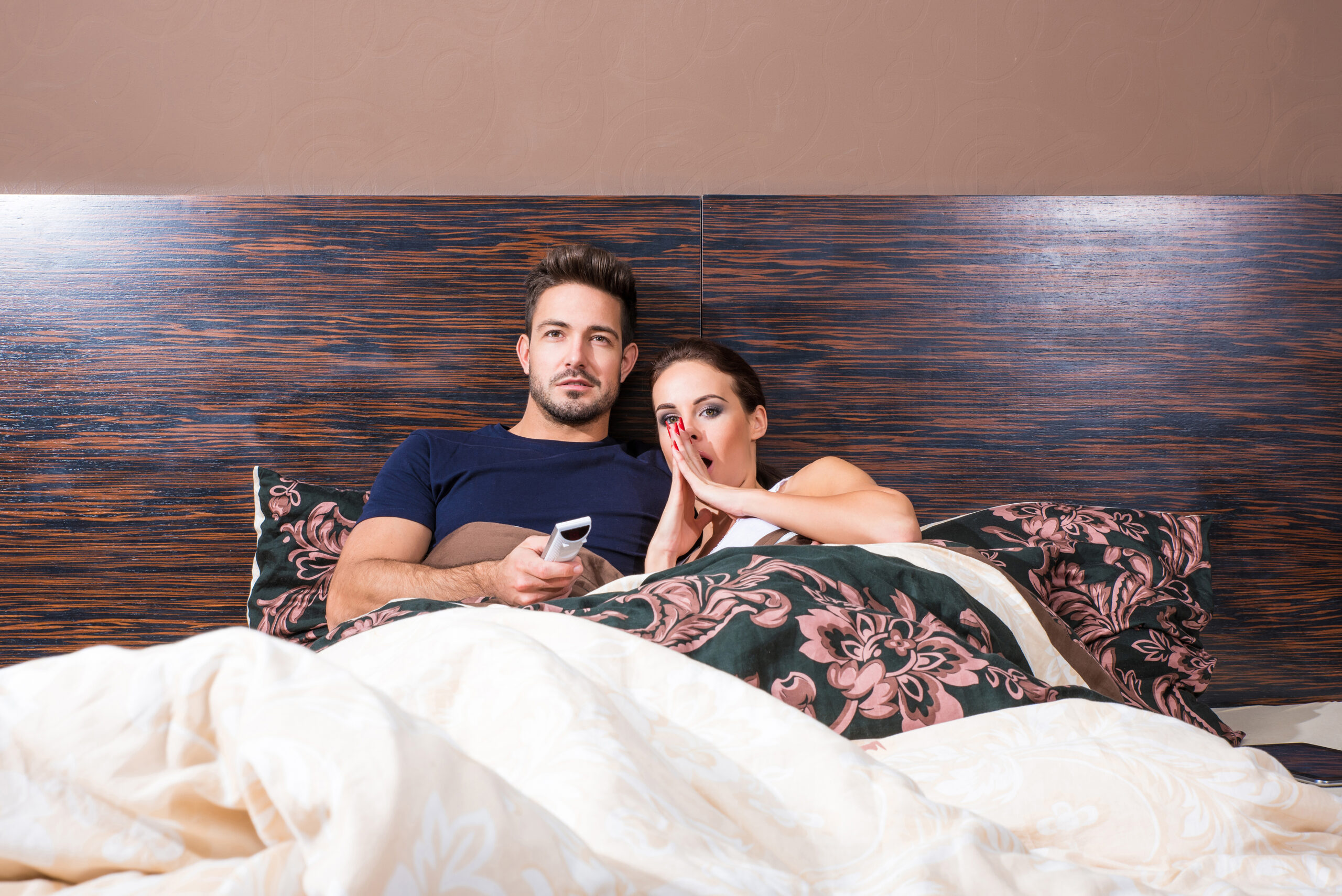 Couple in bed watching TV.