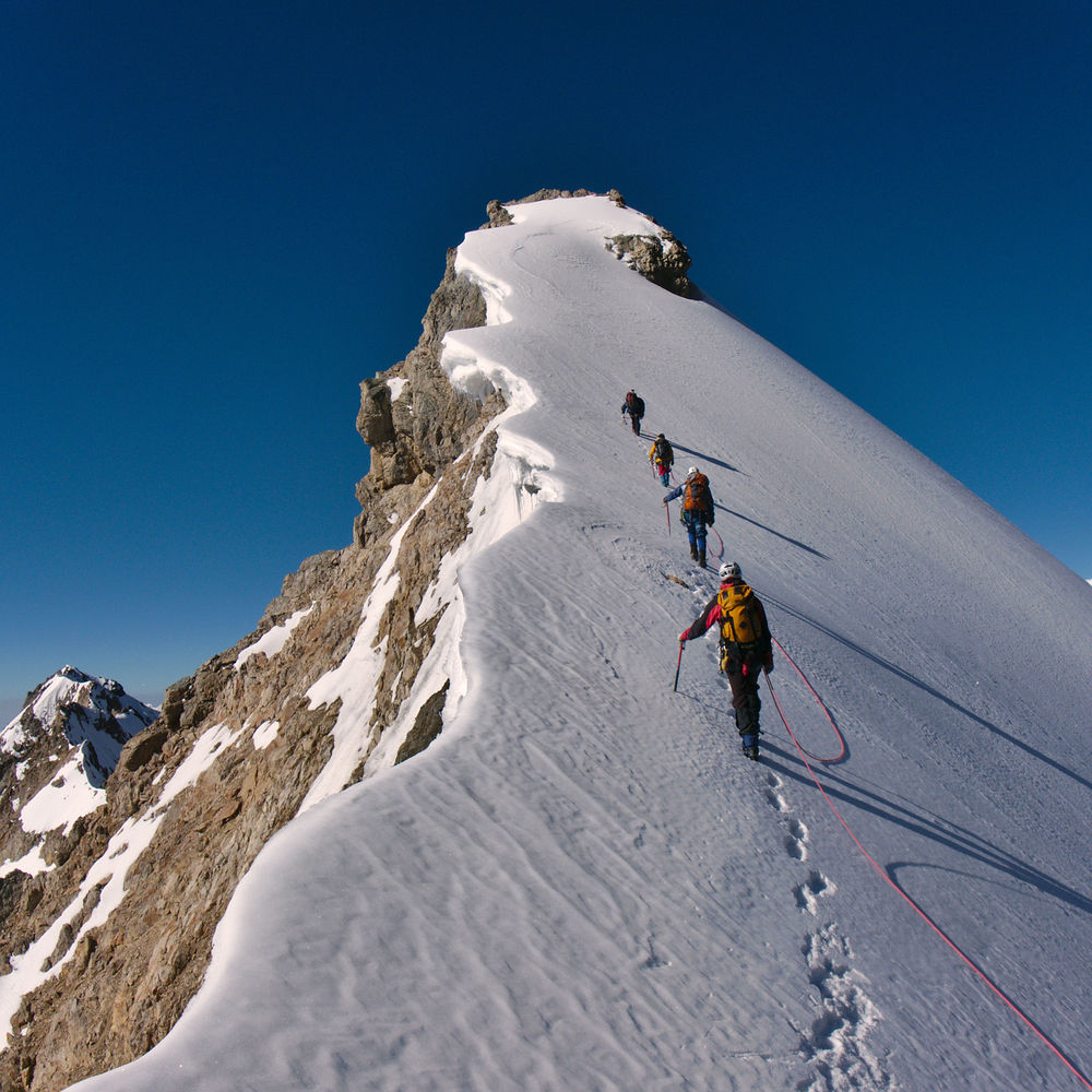 Climbers hiking a snowy mountain.