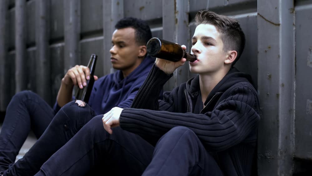 Teen boys drinking outside. 