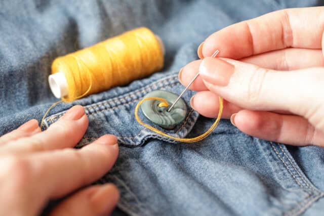 Woman sewing a button.