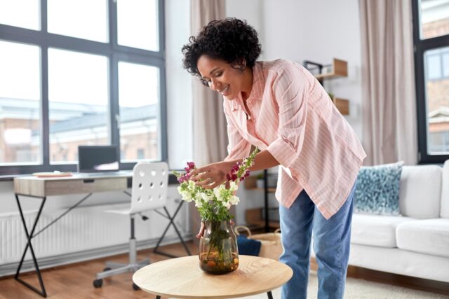 Woman at home taking care of her plant.