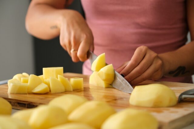 Woman cutting potatoes.