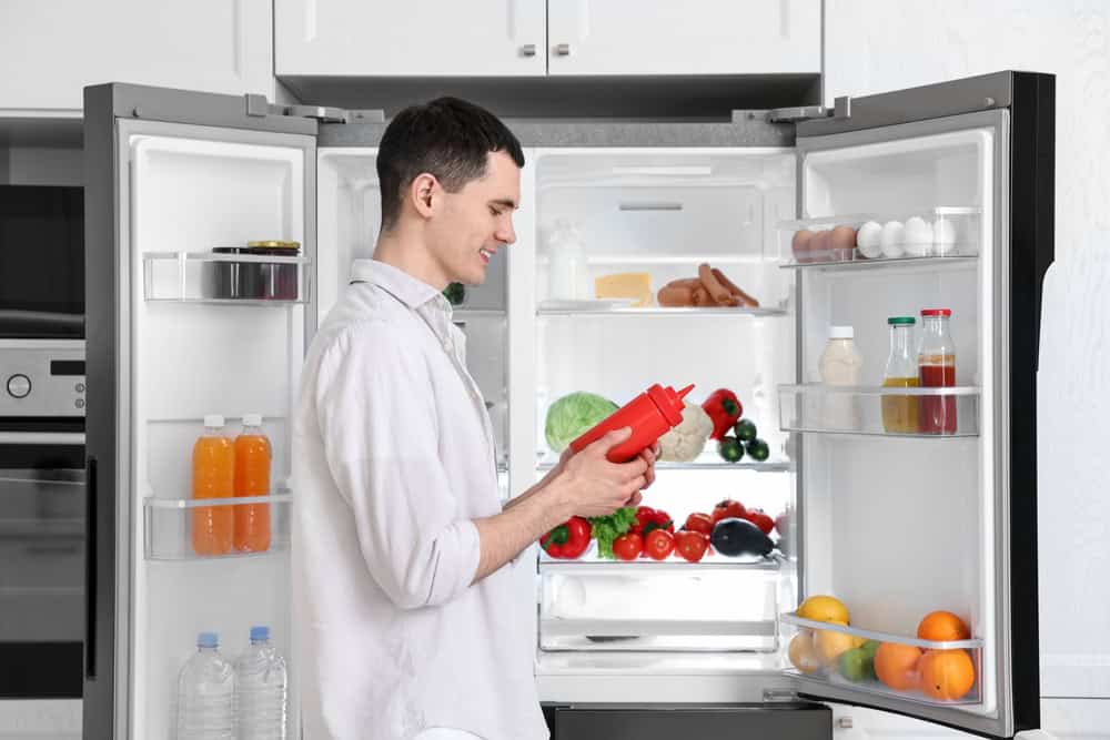 Man standing in front of refrigerator.