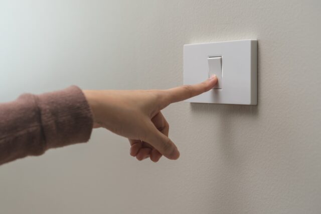 Hand on a light switch.