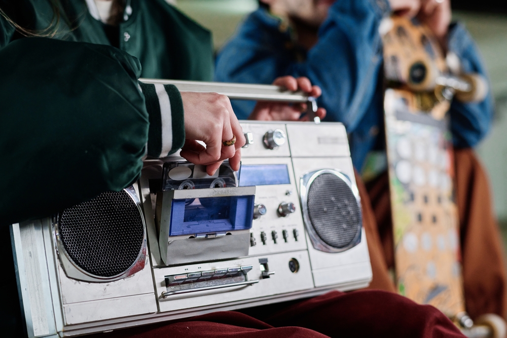 People listening to a vintage cassette player.